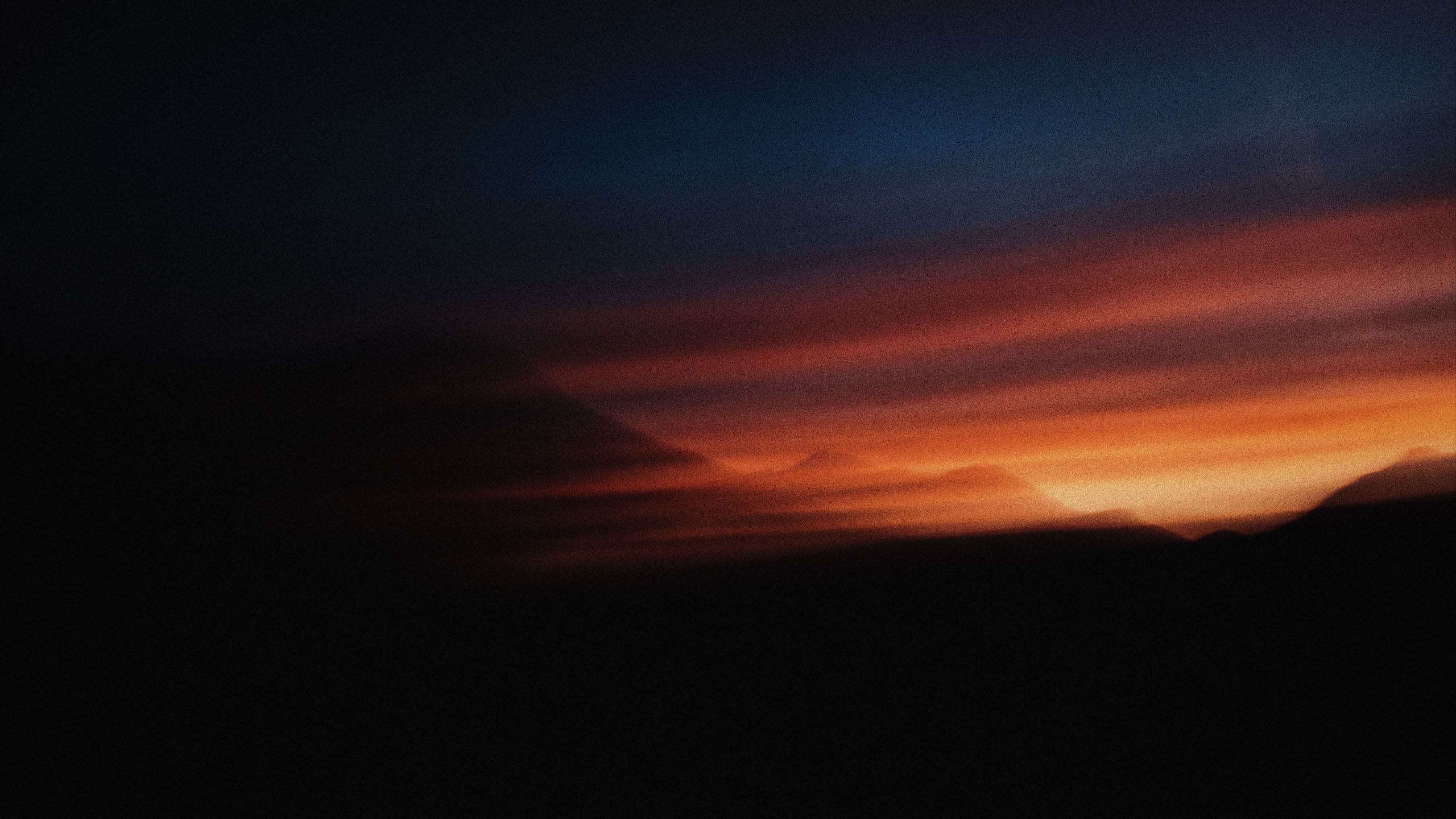 Mountain ridges under an orange dusk sky