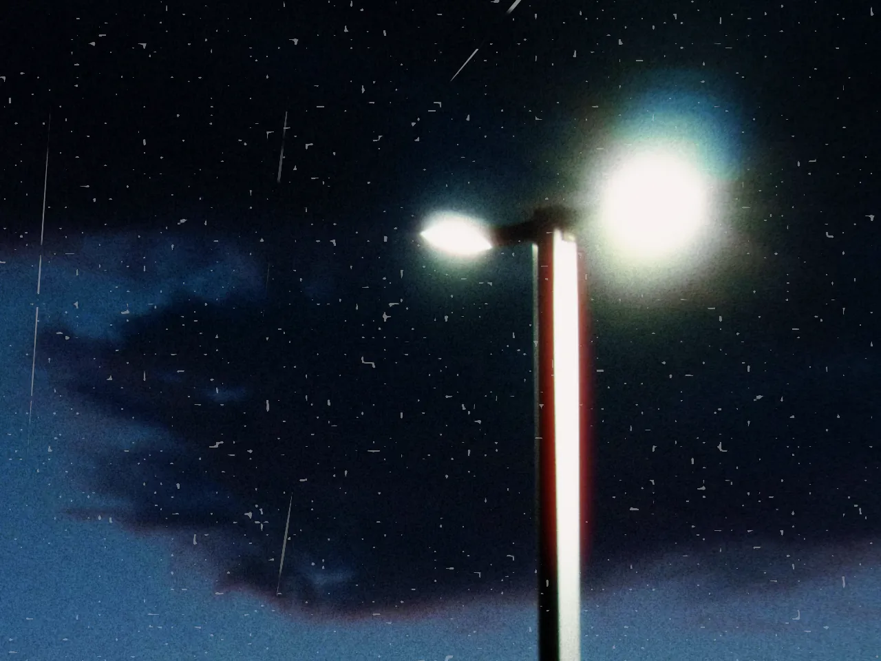 Street lamps silhouetted against an orange and blue sunset sky, with dust & scratches at 50%, shown at 100%