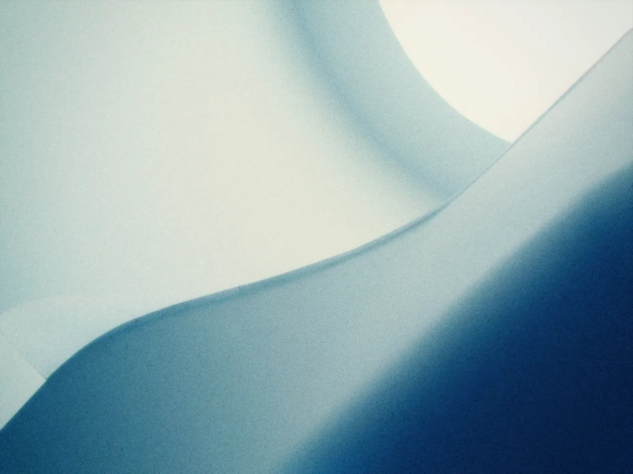Smooth white and blue curved surfaces meeting in soft light, with film curve at 50%