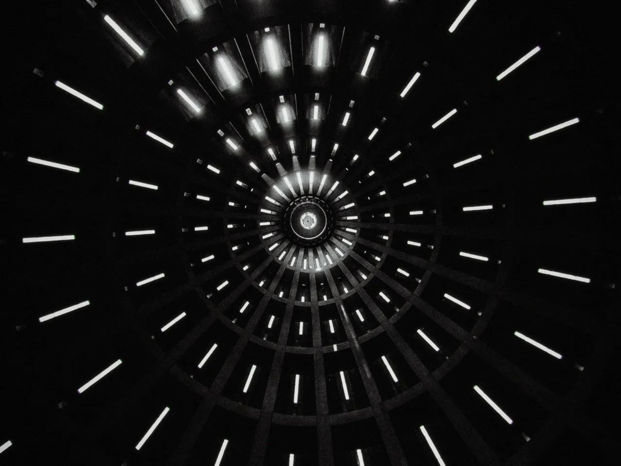 Looking straight up into a round ceiling of radiating strip lights, with shadows at 0